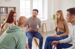 A man talks in a peer support group for addiction recovery.